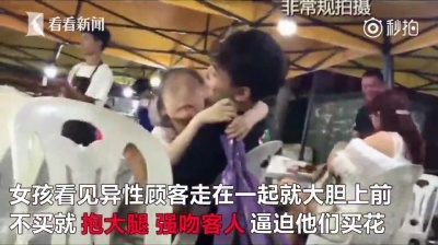 花束を手に、無理やり男性客に抱きつく少女(この件を伝えるニュース映像サイト「看看新聞」より)