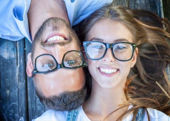 portrait of young couple lying on wooden bench