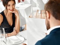 Romantic Couple In Love Having Dinner In Luxury Gourmet Restaurant. Happy Beautiful Lovely People Reading Menu, Choosing Food, Celebrating Anniversary Or Valentine's Day. Romance And Relationships.
