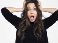 Portrait of a shocked woman with mouth open standing isolated on a white background