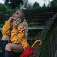 Girl sitting on a stairs and talking on a mobile phone.