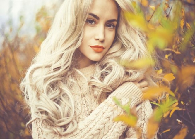 Outdoor fashion photo of young beautiful lady surrounded autumn leaves