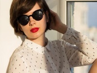 Girl with sunglasses daydreaming sitting by the window