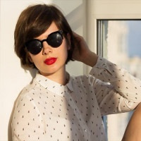 Girl with sunglasses daydreaming sitting by the window