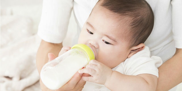 哺乳瓶でミルクを飲ますママ