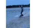 雨も楽しみに変えてしまおう！　大雨後の道路脇でウェイクボードを楽しむ男性。
