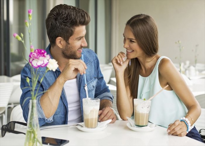 Smiling couple in cafe enjoying the time spending with each other