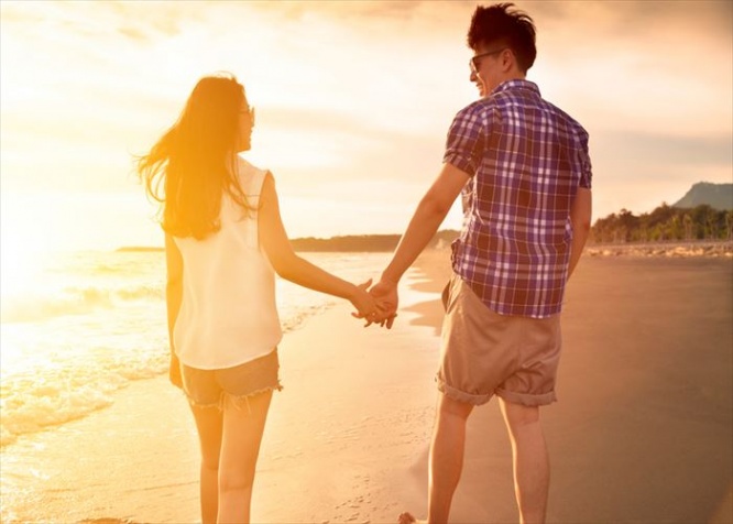 young couple enjoying a beach walk at sunset