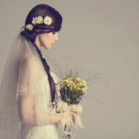 Studio shot of young beautiful bride on light background. Professional make up and hair style.