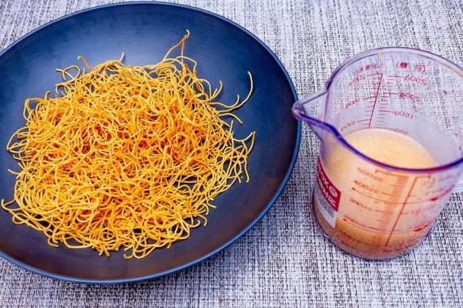 パリパリ細麺を皿に開け、あんかけの素を水で溶かす（写真はマルタイ）