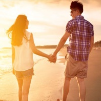 young couple enjoying a beach walk at sunset