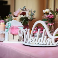 Decor wedding ceremony word wedding on the bank on the background of flowers and candle