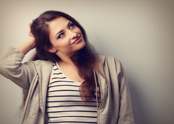 Thoughtful happy beautiful young woman holding the head and looking up. Vintage portrait