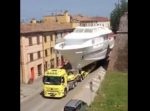 建物にぶつからないかヒヤヒヤ…　市街地で大きな船を運ぶトレーラーの映像。