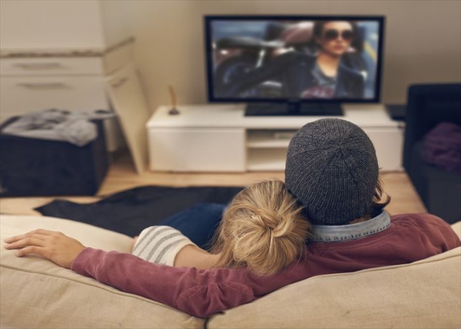 Rear view shot of a young couple watching TV together