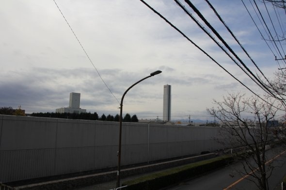 目的地、東芝府中事業所のエレベーター試験塔と府中刑務所の無機質な塀