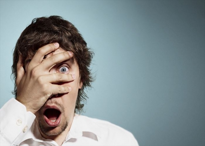 Closeup portrait of handsome young man looking shocked, surprised in disbelief, with hands on face looking at you camera, isolated on background. Positive human emotions, facial expressions