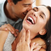 Closeup of beautiful young couple embracing and laughing