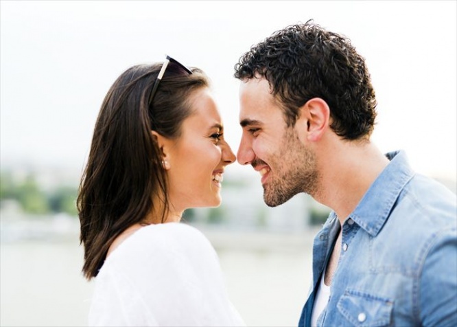 Young beautiful couple rubbing noses as a sign of love and about to kiss each other