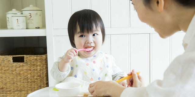 スプーンで食べる子ども