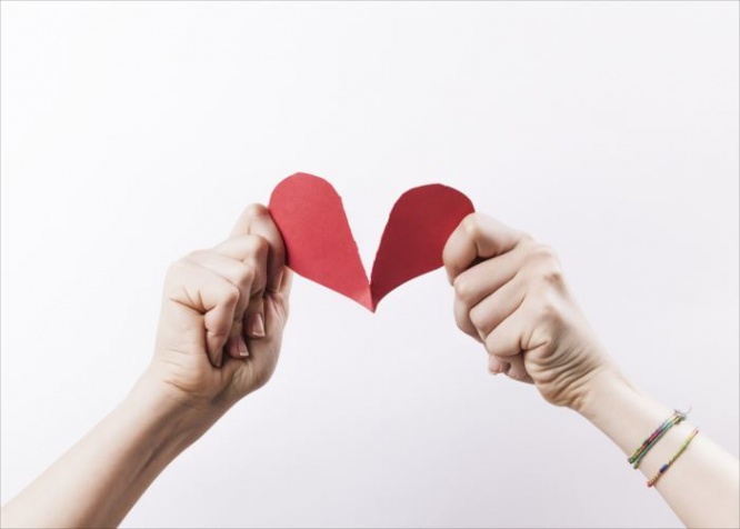 Woman hands tearing red paper heart