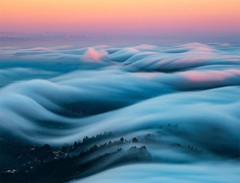 地球をふんわりと白いベールで包み込んでいるような幻想的な霧の風景写真