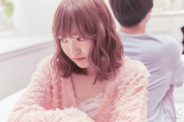 彼氏と背中合わせの寂しそうな女性