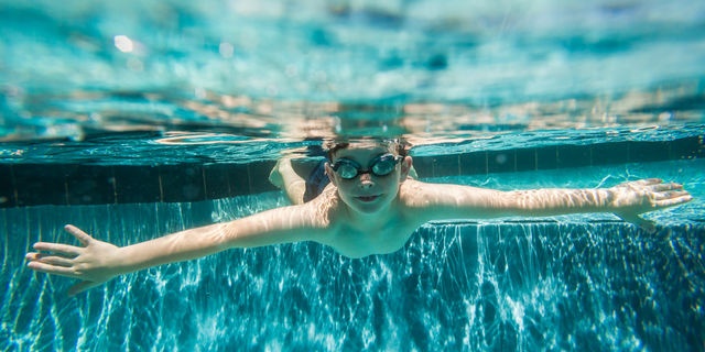 プールの中に潜る海外の少年