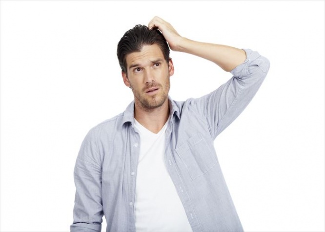 Attractive man scratching his head and looking away thoughtfully, isolated on white