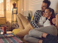 Happy couple sitting embraced in the living room and enjoying in their time together.