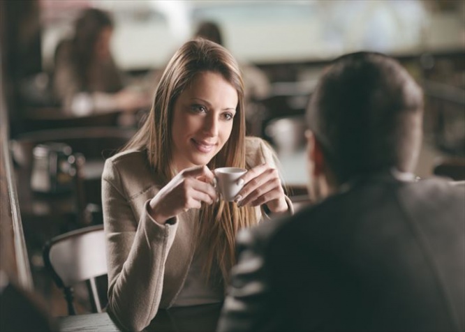 Young fashionable couple dating at the bar, she is having a coffee