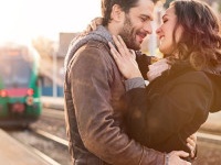 Happy couple embracing on railway station platform