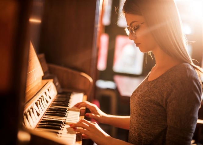 Young female pianist enjoying while practicing on retro styled piano.
