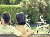 Couple in love hugging each on a bench with bikes