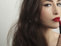 beautiful young woman apply red lipstick, studio shot