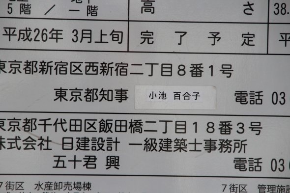 工事看板。東京都知事の項目は、いささか不自然な感じに、シールで「小池百合子」と上書きされている。M記者が「何回も貼り変わっちゃったから......」