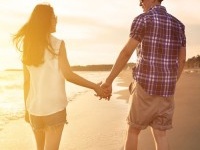 young couple enjoying a beach walk at sunset