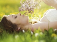 Beautiful girl is relaxing lying on grass in the garden