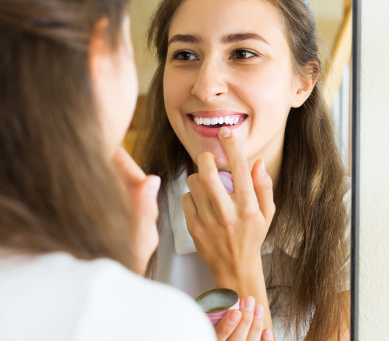 Teenager applying lipstick