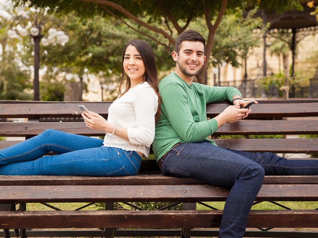 Happy young couple using technology