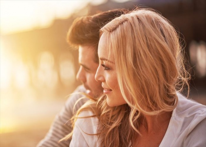 pretty girl cuddling with boyfriend on beach at santa monica