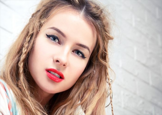Boho Girl Close-Up Portrait at White Brick Wall Background. Bohemian Fashion Woman Portrait. Toned Photo with Copy Space.