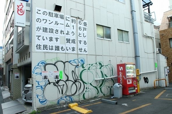 貼り紙と落書きが目立つ壁面