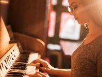 Young female pianist enjoying while practicing on retro styled piano.