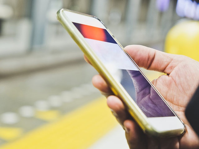 ホームでスマホを持つ人の手