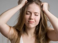 Stress and frustrated woman with hands in her long hair pulling.