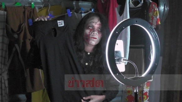亡くなった人の遺品の衣類をゾンビ姿で売る女性（タイ）