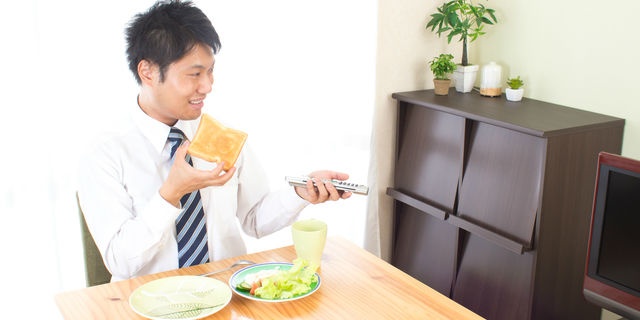 テレビを見ながら食べる男性