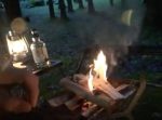 雨滴る森の中でソロキャンプの魅力を伝える男性。