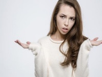 Portrait of a young casual woman shrugging shoulders isolated on a white background